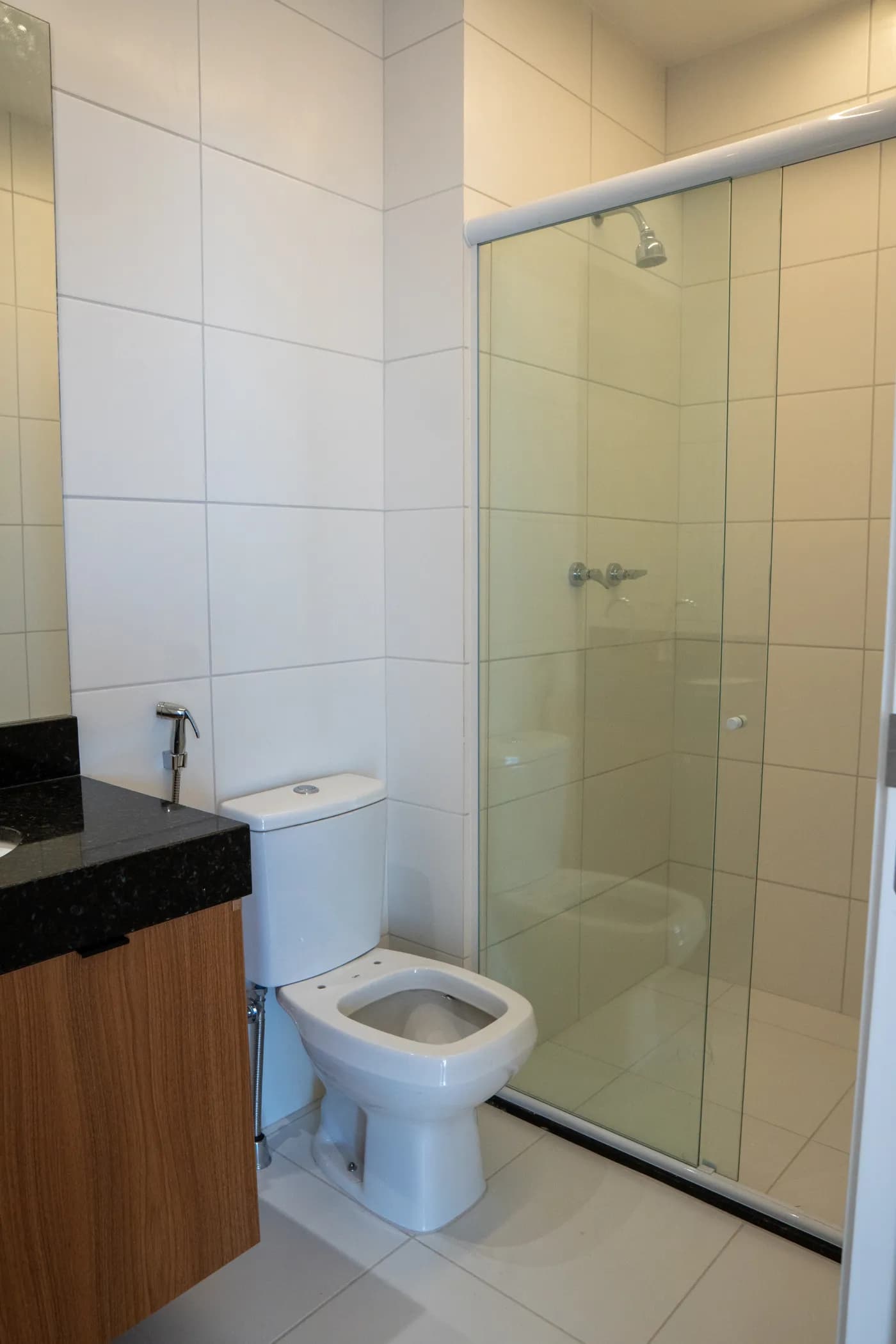 Banheiro do apartamento Torre Evidence com box de vidro e bancada em granito