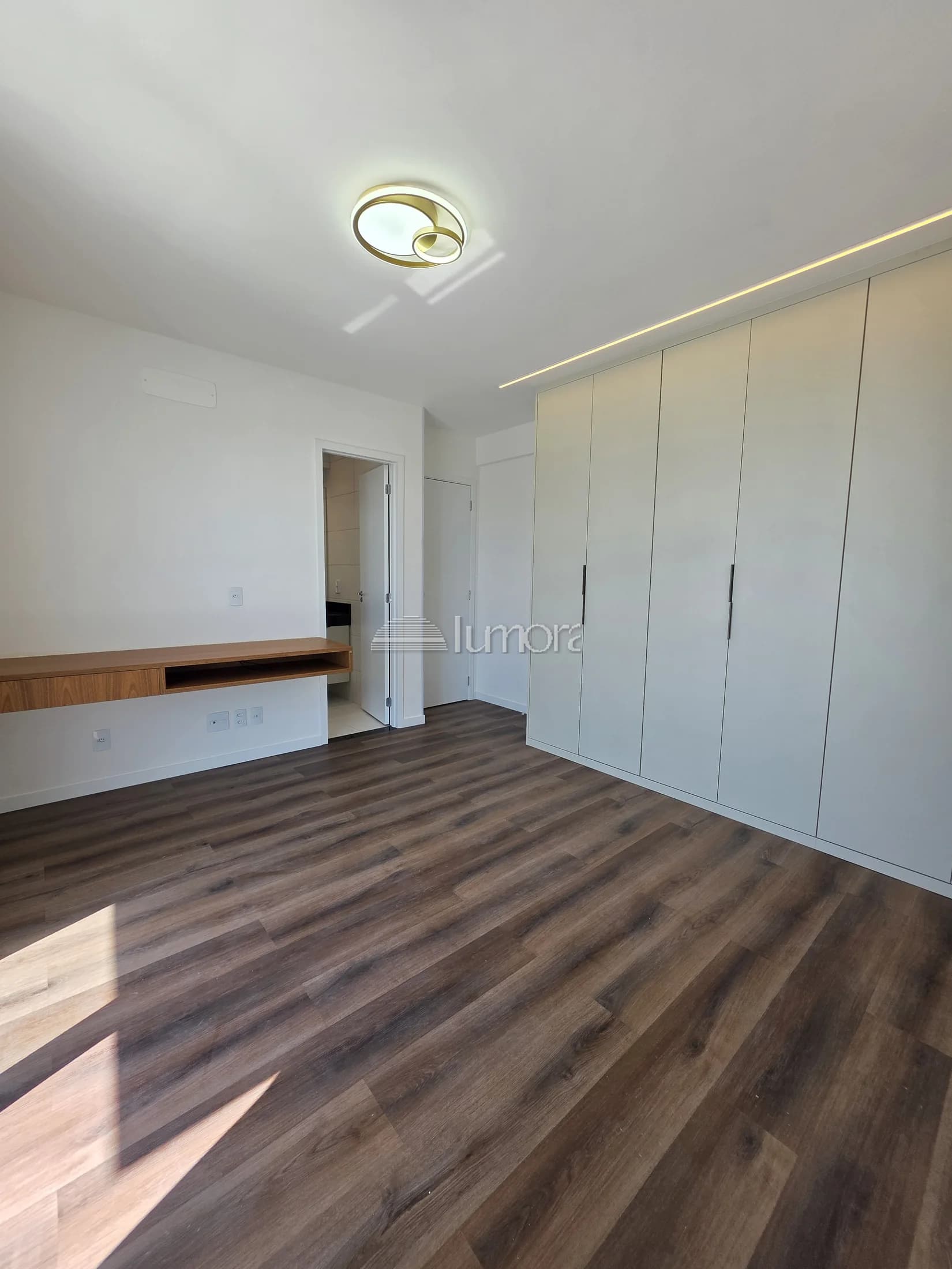Quarto do Torre Evidence com armários planejados e bancada de apoio