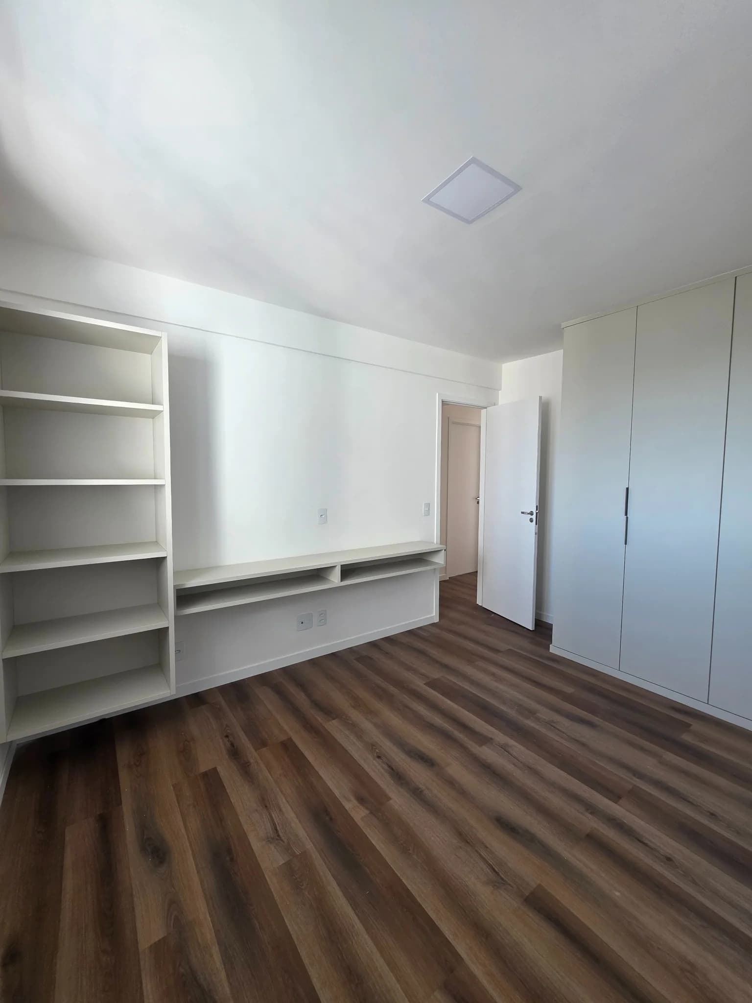 Quarto do apartamento Torre Evidence com móveis planejados e bancada